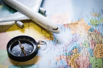selective focus miniature tourist compass map with plastic toy airplane abstract background travel concept 1